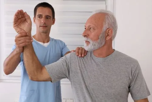 Senior male patient receiving chiropractic care for shoulder arthritis.