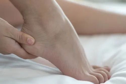 Plantar fasciitis causing heel discomfort for woman in bed