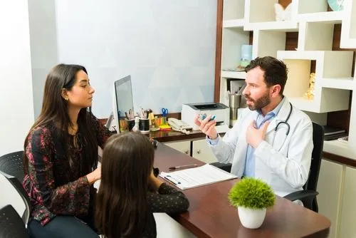 Doctor explaining allergy and asthma management to mother and child