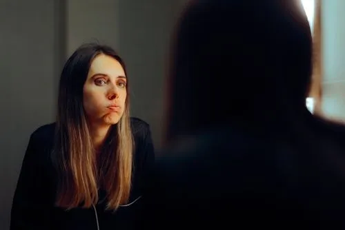 Woman talking to a mirror doubtful