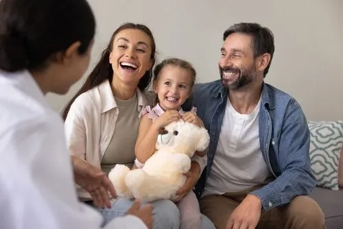Pediatrician consulting with a happy family during a routine visit