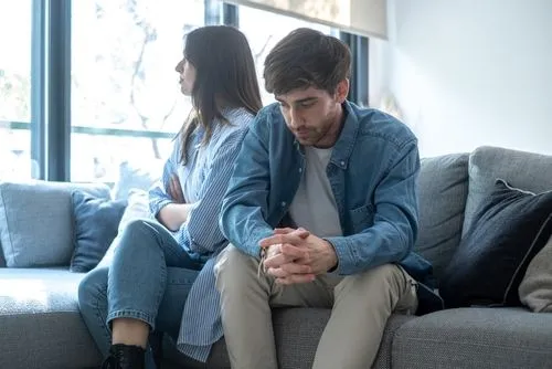 Couple sitting apart and looking upset while dealing with relationship conflict
