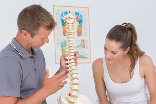 doctor showing spine model to a patient