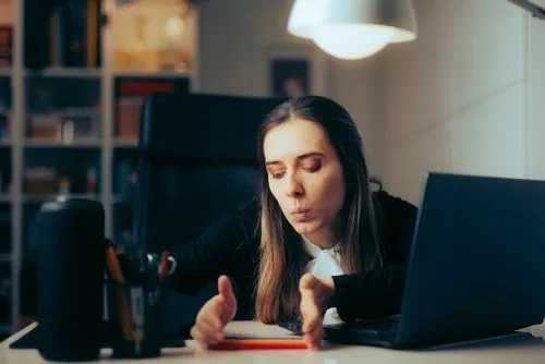 Woman playing pen on table with the laptop