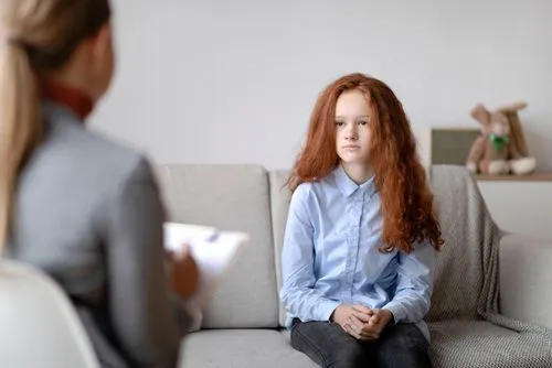 Teenager during a one-on-one therapy session with a mental health professional.