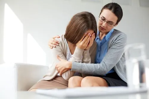 Therapist hugging the woman in grief