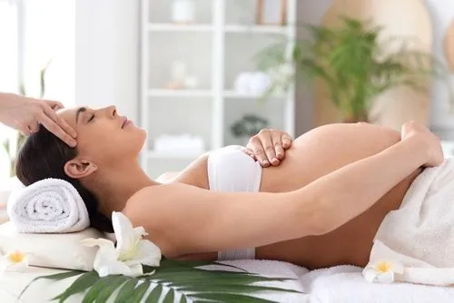 A pregnant woman receiving a prenatal massage for relaxation and comfort.