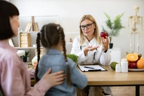 Pediatrician providing nutritional advice to young patient