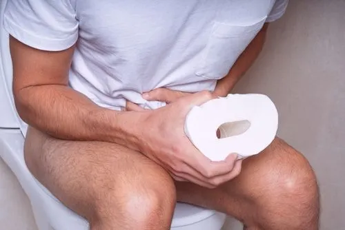 Man sitting on toilet suffering from diarrhea