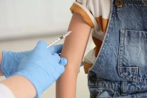 Child receiving vaccination from pediatrician