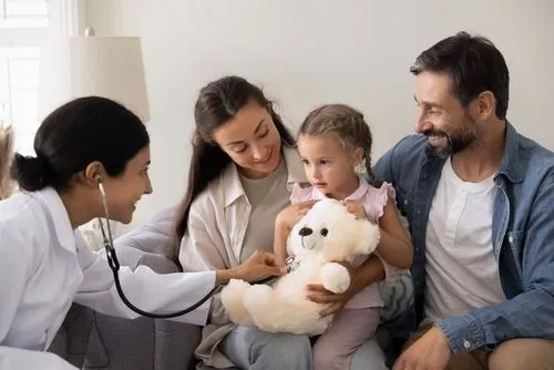 Family medicine doctor examining a young girl while her parents look on