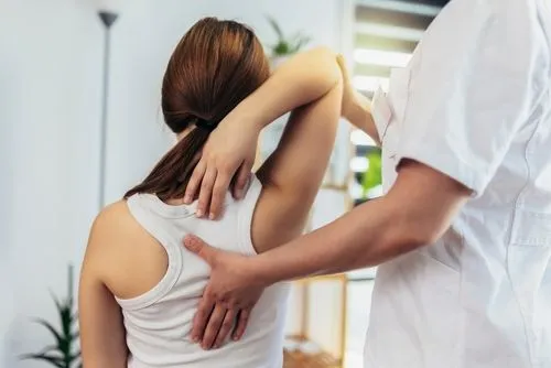 Chiropractor treating a female patient’s back pain.
