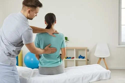 Woman undergoing chiropractic treatment for back pain.