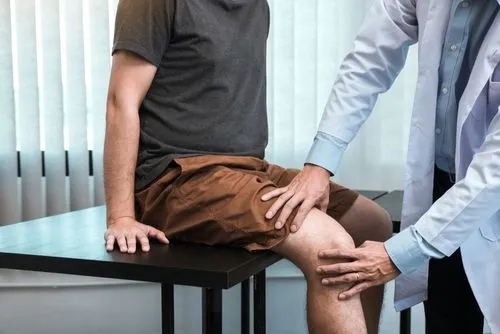 Chiropractor providing knee pain treatment to a male client