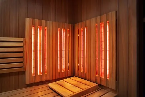 Wooden sauna room with integrated infrared panels for therapeutic use