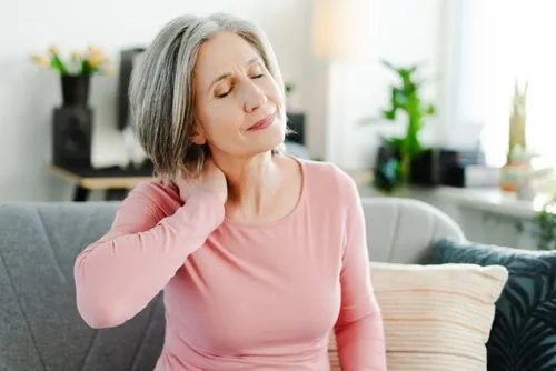 Senior female patient holding neck due to discomfort