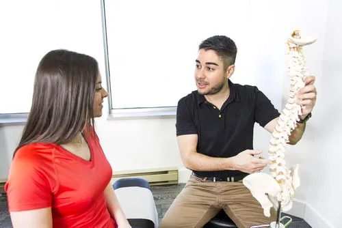 Chiropractor discussing spinal injury treatment with female client