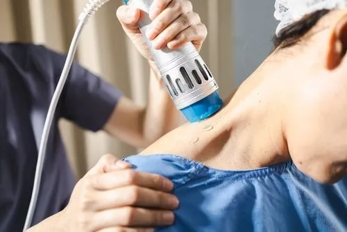 Female patient receiving shockwave therapy from a chiropractor for pain relief