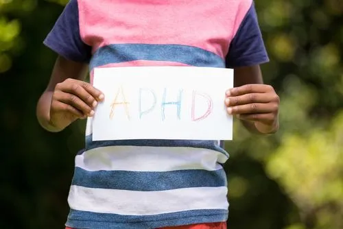 Child showing paper with ADHD written