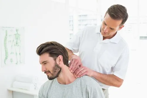 Chiropractor treating male patient with neck pain