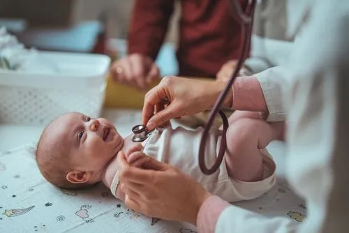 Pediatric specialist assessing a newborn baby's vitals and overall health.