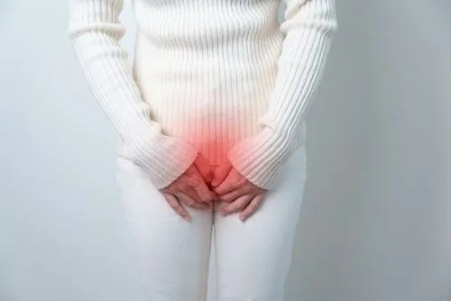 Close-up of woman holding pelvic area due to pain