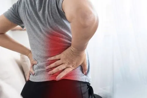 Woman experiencing sciatica pain, holding her lower back