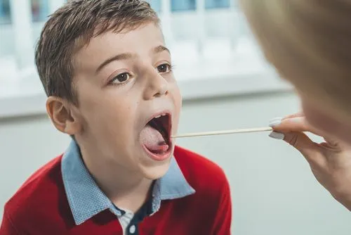 Child receiving evaluation for strep throat from a pediatrician