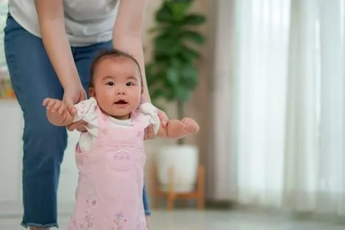 Asian baby learning to walk with the mother