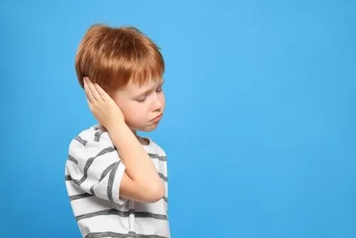 Young boy holding his ears in pain