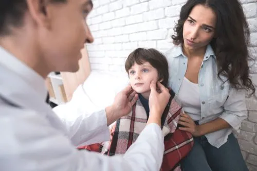 Sick child visiting pediatrician with mother