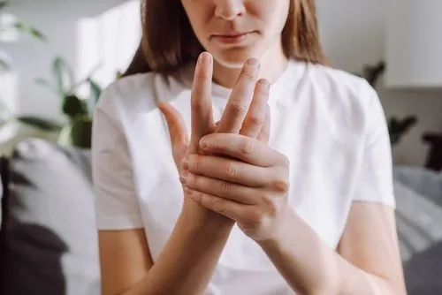 Woman holding her hands due to numbness caused by neuropathy