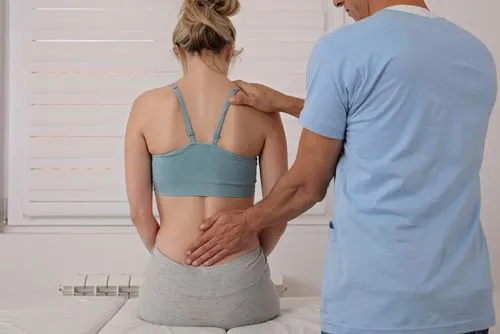 Chiropractor providing treatment for a female client’s back pain