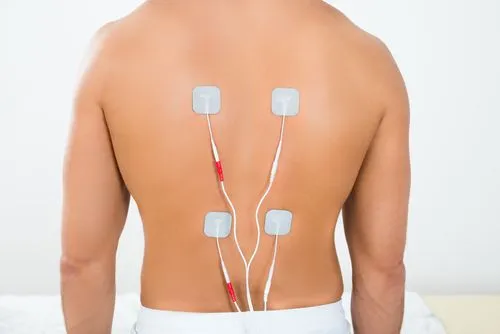 Man receiving electrical stimulation therapy on his back