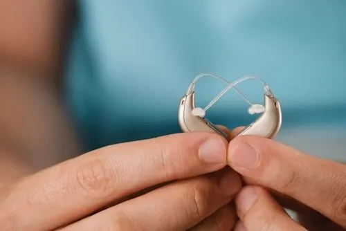 Woman holding and showing hearing aids in a close-up view