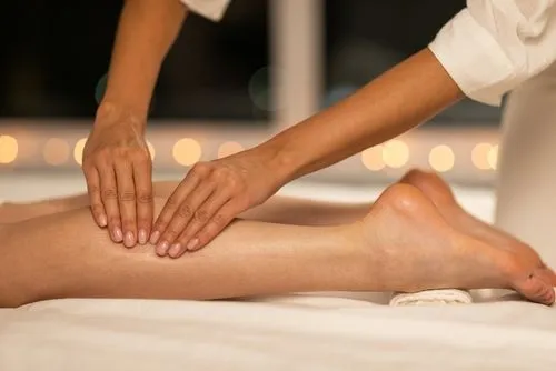 Therapist performing soft tissue therapy on a patient’s legs to relieve muscle tension