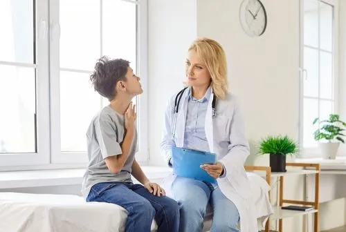 Pediatrician examining a child with throat pain