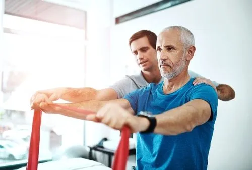Client using resistance band under chiropractor's guidance during physical therapy session