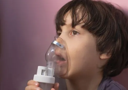Young boy using an oxygen inhaler