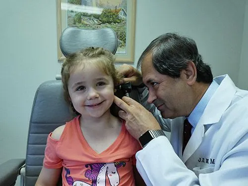 ENT doctor examining child's ear