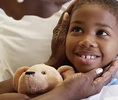 mother holding daughter's head in her hands while she's holding teddy bear