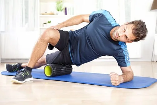 A guy doing exercise with a foam roller