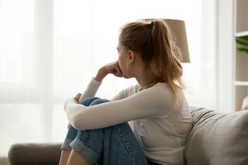 Woman Sitting On Couch Thinking