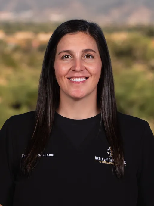 Smiling chiropractor with model of spine.
