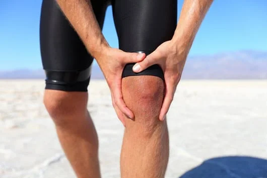 A man grips his leg