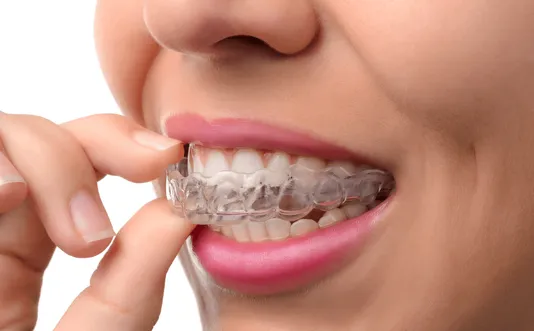 Woman holding Invisalign, Gainesville General Dentist