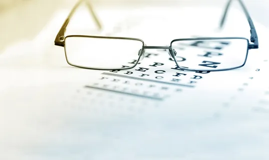 Eyeglasses on top of an eye chart