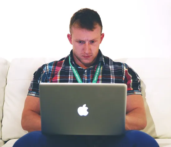 Man on couch looking at his laptop computer