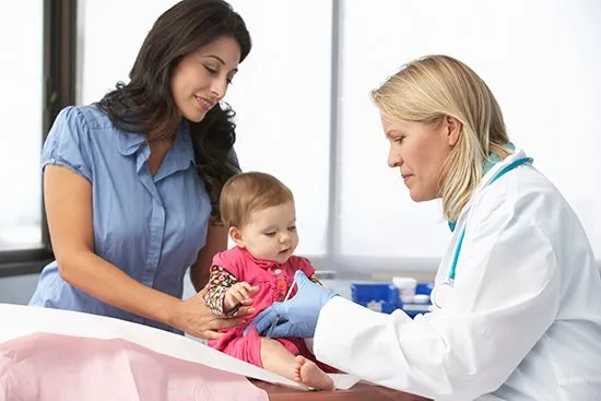 mother holding child during doctors appointment