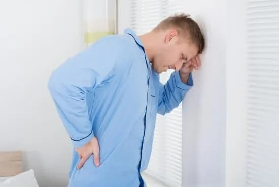 Man holding his lower back in pain and in need of chiropractic care